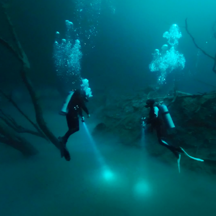 Divers hover above the Hydrogen Sulfide cloud at 27 meters/90 feet at Cenote Angelita near Tulum