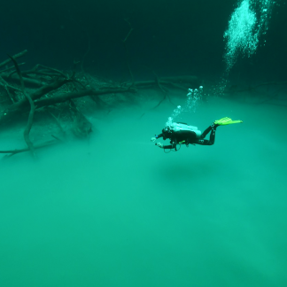 a diver hovers above the Hydrogen Sulfide cloud at 27 meters/90 feet at Cenote Angelita near Tulum