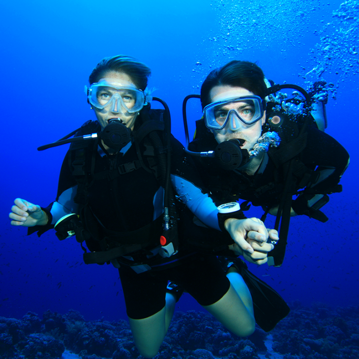 happy couple celebrates by scuba diving together in Playa del Carmen