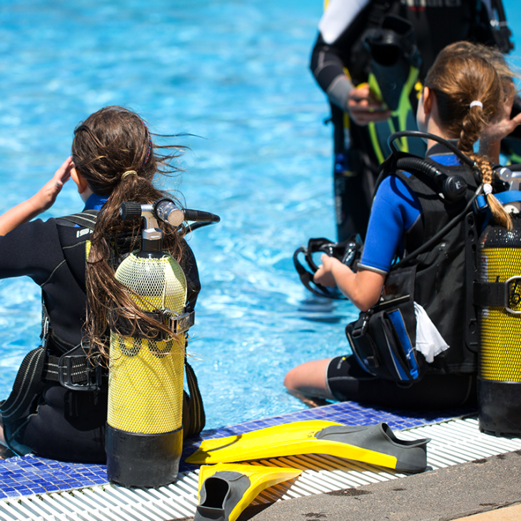 Scuba divers testing their equipment during their course in the pool